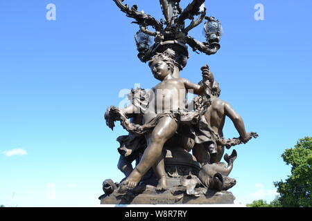 Nahaufnahme Strassenlaterne mit Bronze Skulpturen des Alexander III Brücke über die Seine in Paris an einem sonnigen Sommertag an blauen Himmel zu verzierten. Stockfoto