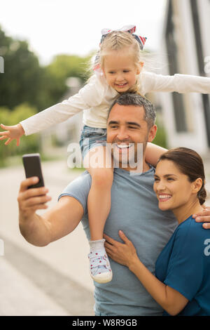 Freundliche Familie lächelnd, während sie alle zusammen selfie Stockfoto