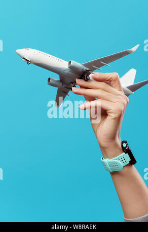 Bild von Hand mit Flugzeug auf leeren blauen Hintergrund Stockfoto