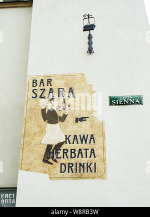 Krakau, Poland-June 10,2015: verwitterte Schild mit einem Richtungspfeil in eine Bar Stockfoto