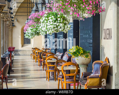 Krakau, Poland-June 10,2015: Coffee Shop in den Arkaden der Tuchhallen in Krakau mit Stühlen aus Holz und Hängende Blumentöpfe Stockfoto