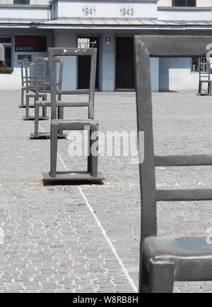 Krakau, Poland-June 11,2015: Square in Podgorze in Krakau mit einem Ghetto Memorial mit leeren, Bügeleisen Stühle Stockfoto