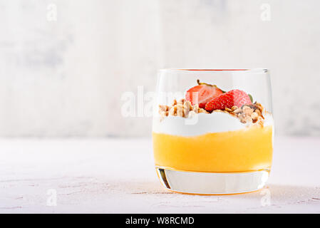 Vorderansicht eines Glas vegetarisch Dessert aus Mango Smoothie, Ricotta, Muscheln und Erdbeeren mit Kopie Raum Stockfoto