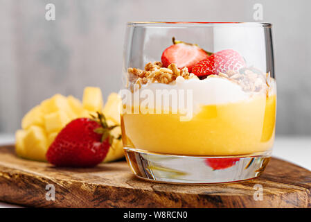 Close-up von puff Dessert Mango Smoothie, ricotta Käse Sahne, gebackenes Müsli mit Erdbeeren Stockfoto