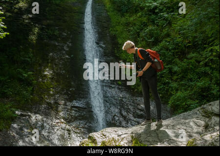 Junge Fotografen die Bilder mit Smartphone im Wald Stockfoto