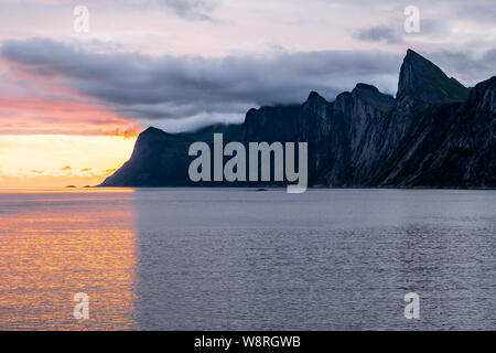 Eindrucksvolle Gebirge Segla über einem Fjord um Mitternacht bei bewölktem Himmel, bunte Senja, Norwegen Stockfoto