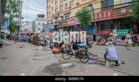 MISHAN, CHINA - Juli 27, 2019: Unbekannter Menschen vor Ort kaufen und verkaufen Produkte in einem lokalen Gemüsemarkt. Stockfoto