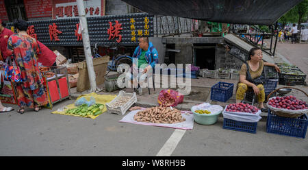 MISHAN, CHINA - Juli 27, 2019: Unbekannter Menschen vor Ort kaufen und verkaufen Produkte in einem lokalen Gemüsemarkt. Stockfoto