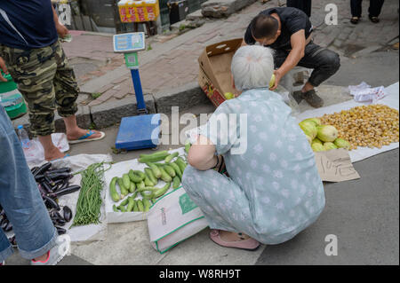 MISHAN, CHINA - Juli 27, 2019: Unbekannter Menschen vor Ort kaufen und verkaufen Produkte in einem lokalen Gemüsemarkt. Stockfoto