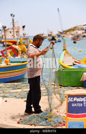 Marsaxlokk, Malta: 16. Mai 2019: Traditionell gemusterte bunte Boote Luzzu im Hafen von mediterranen Fischerdorf Marsaxlokk, Malta Stockfoto