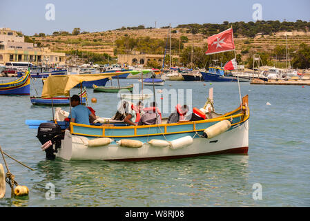 Marsaxlokk, Malta: 16. Mai 2019: Traditionell gemusterte bunte Boote Luzzu im Hafen von mediterranen Fischerdorf Marsaxlokk, Malta Stockfoto