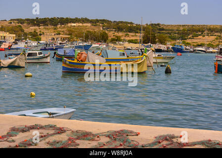 Marsaxlokk, Malta: 16. Mai 2019: Traditionell gemusterte bunte Boote Luzzu im Hafen von mediterranen Fischerdorf Marsaxlokk, Malta Stockfoto