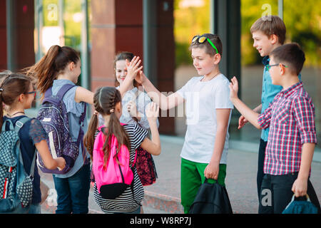 Mitschüler zur Schule gehen. Studenten begrüßen sich. Stockfoto