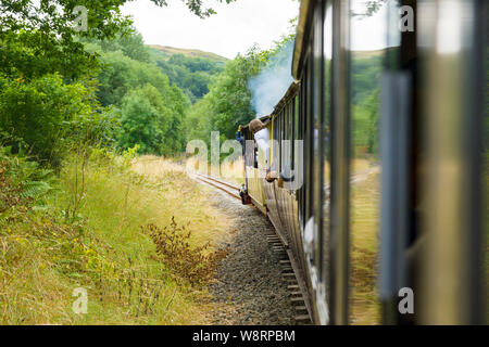 Passagiere lehnte sich aus dem Wagen auf einem Bala Lake Railway Schmalspur Dampflok eine Reise um Bala Lake im Norden von Wales Stockfoto