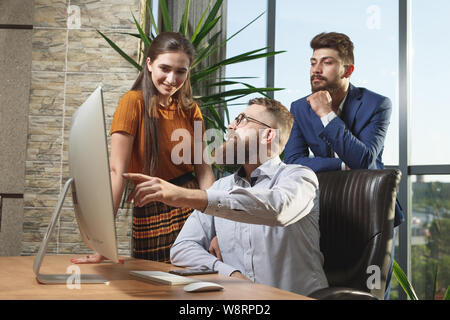 Geschäftsleute in einem modernen Büro Arbeit vor dem Bildschirm zu diskutieren. Stockfoto