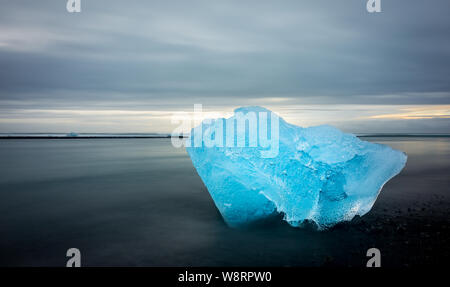 Eisberg in einem schwarzen Sandstrand, erinnert an ein Diamant, in Island Stockfoto