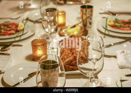 Festliche Tisch mit Brot, Gläser, Entree und Kerzen Stockfoto