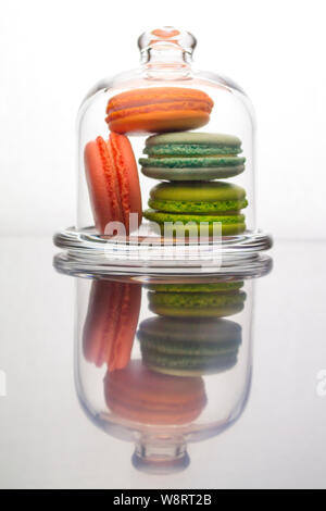 Makronen Kuchen in einem Glaskasten. Bunte französische Kuchen Dessert hinter Glas, vertikale Spiegelung Stockfoto