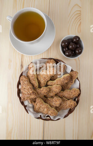 Eine Tasse Tee mit Zucker Cookies in Form von Weihnachtsbäumen und Schokolade Dragiermaschinen u.a., Teezeremonie mit Süssigkeiten Dessert, vertikale Ansicht von oben Stockfoto