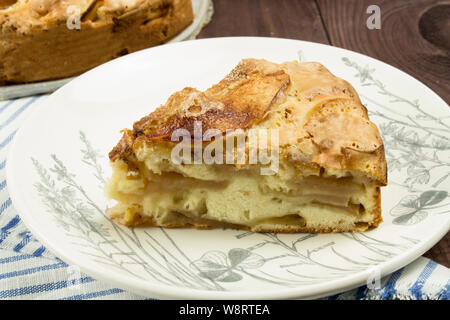 Ein Stück hausgemachten Apfelkuchen, klassische Strudel auf einem weißen Teller mit großen Scheiben von Äpfeln, close-up. Stockfoto