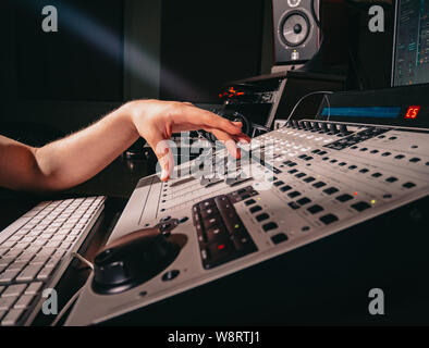 Nicht erkennbare sound Hersteller Ingenieur dreht blättert Rad auf der Mixing Console Stockfoto