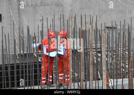 (190811) -- GUIPING, Aug 11, 2019 (Xinhua) -- Ingenieure auf der Baustelle der Dateng Schlucht hydro Dam in Guiping, South China Guangxi Zhuang autonomen Region, 10.08.2019 diskutieren. Gelegen in der Stadt von Guiping, die dateng Schlucht hydro Dam ist für mehrere Zwecke einschließlich Hochwasserschutz, Navigation und Power Generation ausgelegt. Insbesondere wird es Fluss Salzgehalt während der trockenen Jahreszeit zu reduzieren, damit die Qualität der Wasserversorgung gewährleistet zu Pearl River Delta Städte einschließlich Macau. (Xinhua / Cao Yiming) Stockfoto