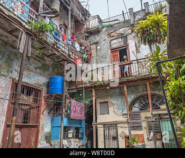 Havanna, Kuba - April 09, 2019: Frau auf einem Balkon eines depressiven Wohngebäude in der Altstadt Stockfoto