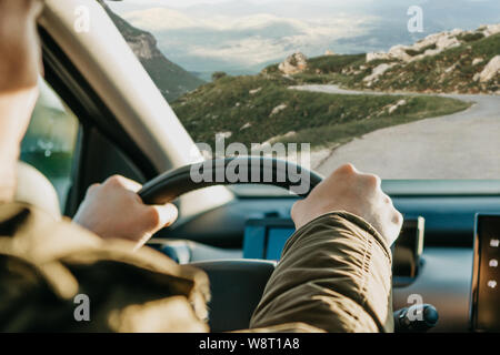 Close-up. Die Hand des Fahrers auf das Lenkrad. Der Treiber oder Reisenden oder Tourist ist ein Auto fahren. Stockfoto