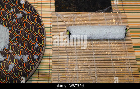 Die Sushi in einem japanischen Küche mit orientalischen und traditioneller Dekoration. Prozess, Sushi, Sushi Roll mit Gemüse, Ansicht von oben. Stockfoto