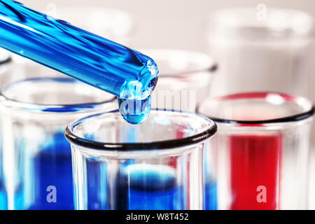 Close-up ein Tropfen Flüssigkeit auf einer Pipette in ein Reagenzglas fallen. Chemischen oder medizinischen Test. Stockfoto