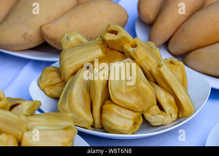 Frische jackfruit Schichten auf einem weißen Teller. Süße gelbe Jackfruit reif. Vegetarier, Veganer, roh essen. Tropische Frucht in Thailand, Nahaufnahme Stockfoto