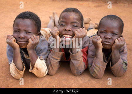 Jungen entspannen Sie sich auf dem Boden in einem abgelegenen Dorf in der Nähe von ntchisi. Malawi ist eines der ärmsten Länder der Welt. Stockfoto