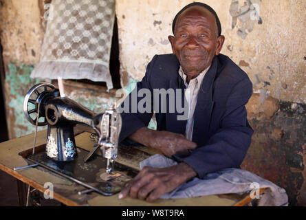 Ein Taylor mit einer Nähmaschine in einem kleinen Dorf in der Nähe von Senga Bay. Malawi ist eines der ärmsten Länder der Welt. Stockfoto