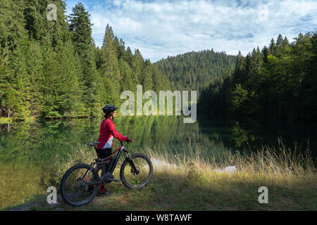 Schöne und immer junge Seniorin mit ihrem elektrischen Mountainbike-Rad am Trinkwasserhochbecken Kinzig im Nordschwarzwald, Baden-Württemberg Stockfoto