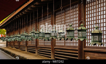 Gruppe der traditionellen bronze Laternen hängen vom Dach der Schrein der Gebäude in Naras Kasuga Taisha liefern ein Muster, Japan, November 2018 Stockfoto