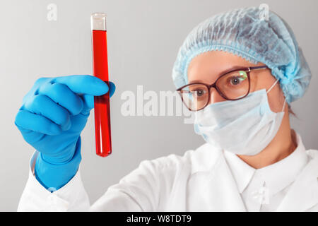Wissenschaftlerin in ein Reagenzglas in einem Labor. Stockfoto