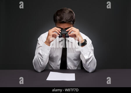 Unternehmer auf der Suche nach einem Dokument durch ein Fernglas Stockfoto