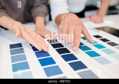 Junge männliche und weibliche Mode Designer bei Farbmuster von textilen zeigen Stockfoto