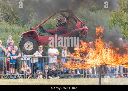 Scott May’s Daredevil Stunt Show in Rayleigh, Essex, Großbritannien. Der Pilot-Buggy springt durch das Feuer, springt Stunt. Flammen Stockfoto