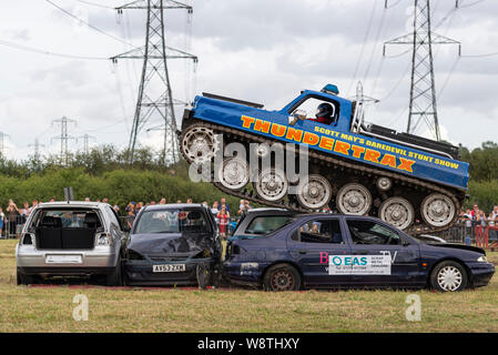 Scott's Mai waghalsigen Stunt Show an Rayleigh, Essex, Großbritannien. Thundertrax Kettenfahrzeug quetsch Autos. Von gepanzerte Mannschaftswagen umgebaut Stockfoto