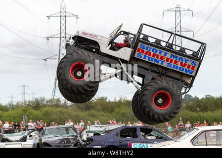 Scott's Mai waghalsigen Stunt Show an Rayleigh, Essex, Großbritannien. Monster Truck springen über und Zerkleinern von Autos Stockfoto