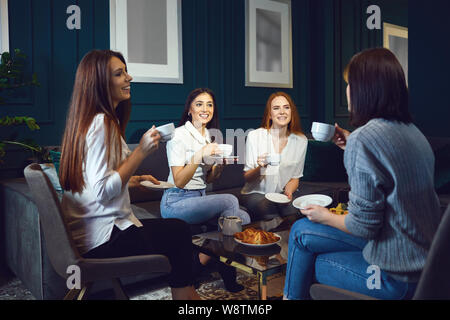 Frauen trinken Kaffee an einem Treffen der Freunde zu Hause lacht. Stockfoto