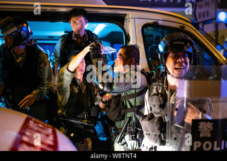 Hongkong, China. 12. August 2019. Ein Polizist bietet ein Kollege Hilfe nach Exposition mit Tränengas bei Anti-Auslieferung bill Proteste sind eine Reihe von laufenden Demonstrationen in Hongkong. # Hongkong China ### extraditionbill antielab yuenlong ##hkprotest Credit: Joshua Preston/Alamy leben Nachrichten Stockfoto