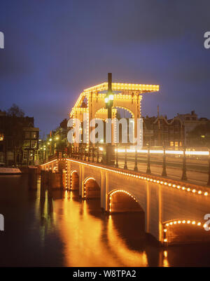 Die Magere Brug (Skinny Bridge) in der Dämmerung und den Fluss Amstel, Amsterdam, Noord-Holland, Königreich der Niederlande Stockfoto