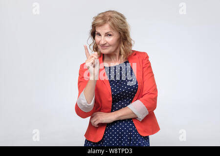 Reife Frau zeigt mit dem Finger auf sie mit einem selbstbewussten Ausdruck Stockfoto