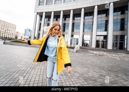 Blonde weibliche hipster Frau reiten auf dem Longboard in der Straße in der Stadt. Stockfoto