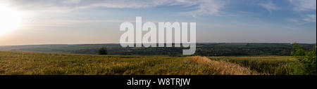 Sonnenuntergang über dem Feld. In der Ferne können Sie das Dorf. Stockfoto