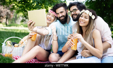 Glückliche junge Freunde unter selfies auf ein Picknick im Freien Stockfoto