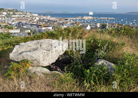 Blick von buzza Hill gegen Hugh Stadt und den Hafen, mit einem jungsteinzeitlichen Grabkammer (Dolmen) im Vordergrund, die St Mary's, Isles of Scilly Stockfoto