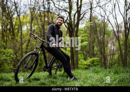 Radfahrer, die mit dem Fahrrad auf der Spur im Wald. Extreme Sport Konzept. Stockfoto